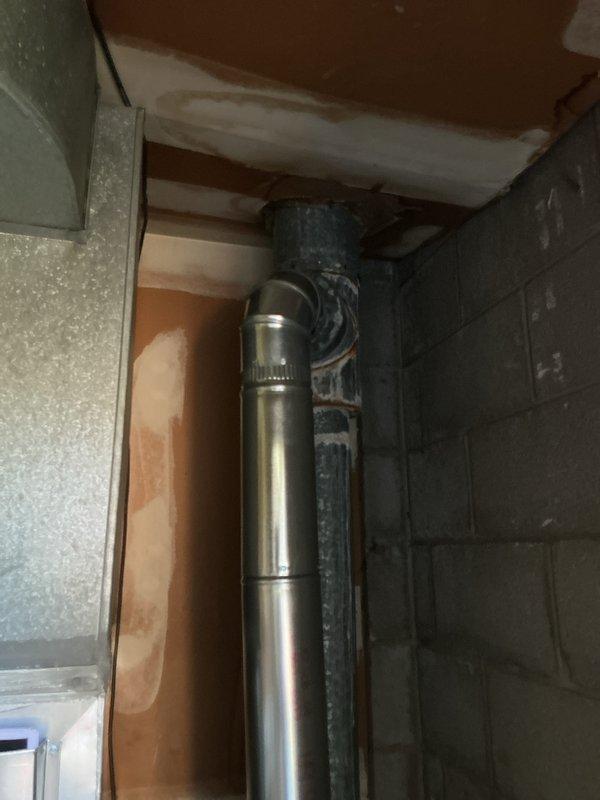 Completed installation of new air conditioning system with evaporator coil in basement utility area. Installed air handler unit with corresponding ductwork connections, integrated with existing furnace system using proper metallic ductwork and flexible conduit. Established new venting system with rigid metal flue pipe through foundation wall, secured all components to wooden platform base, and verified proper clearances per manufacturer specifications.