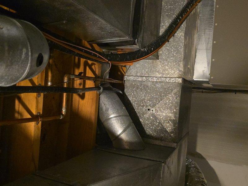 Responded to service call for frozen evaporator coil. Upon arrival, accessed HVAC system in basement utility area and confirmed heavy frost accumulation on evaporator coil and connected ductwork. Customer had previously shut down cooling system and switched to fan-only mode, allowing coil to begin thawing. Performed comprehensive system inspection and cleaning service, documenting conditions with photographic evidence showing extensive ice buildup on refrigerant lines and air handler components. Verified customer had recently replaced air filter prior to service visit. System evaluated for proper airflow and refrigerant concerns that contributed to freezing condition.