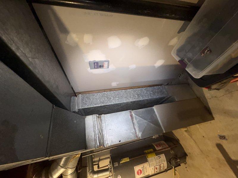 Responded to service call for residential A/C system not cooling properly with suspected low refrigerant charge. Upon arrival, accessed mechanical equipment in basement utility area and performed system diagnostics. Inspected HVAC equipment, ductwork, and associated components in unfinished space with exposed concrete block walls. Evaluated refrigerant levels and system performance to determine root cause of cooling deficiency.
