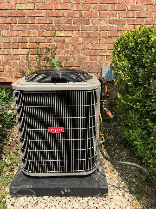Completed installation of new Bryant air conditioning system including outdoor condensing unit and indoor evaporator coil. Positioned condenser on stable plastic pad with proper clearance from structure and landscaping, ensuring adequate airflow around unit. Connected refrigerant lines and electrical service to wall-mounted disconnect box per manufacturer specifications. Installed condensate pump system with PVC drainage piping to handle moisture removal from indoor coil, securing all components with appropriate mounting brackets. Verified proper water flow through condensate trap and pump operation. System tested and confirmed operational with all connections secure and leak-free.