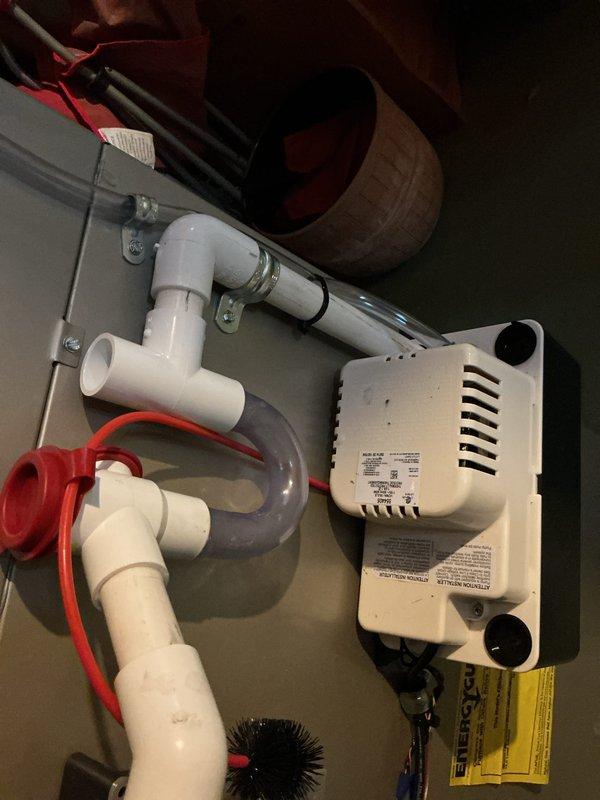 Completed installation of new Bryant air conditioning system including outdoor condensing unit and indoor evaporator coil. Positioned condenser on stable plastic pad with proper clearance from structure and landscaping, ensuring adequate airflow around unit. Connected refrigerant lines and electrical service to wall-mounted disconnect box per manufacturer specifications. Installed condensate pump system with PVC drainage piping to handle moisture removal from indoor coil, securing all components with appropriate mounting brackets. Verified proper water flow through condensate trap and pump operation. System tested and confirmed operational with all connections secure and leak-free.