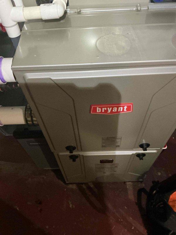 Completed installation of Honeywell IAQ thermostat backplate on Bryant HVAC system. Verified proper mounting and connections to existing furnace/air handler unit with associated PVC condensate drainage and venting system. System operational and warranty service fulfilled.