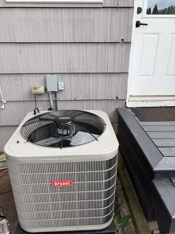Completed installation of new Bryant air conditioning system with matching Goodman furnace and evaporator coil. Installed outdoor condenser unit on concrete pad with proper electrical disconnect, positioned condenser in side yard area adjacent to deck with adequate clearance for service access. Indoor installation included mounting evaporator coil to furnace cabinet in basement mechanical room, connecting refrigerant lines, installing condensate drain with PVC piping, and integrating system with existing ductwork. Verified all electrical connections, tested system operation including compressor function and airflow, confirmed proper refrigerant charge and pressures. System commissioned and operating within manufacturer specifications.