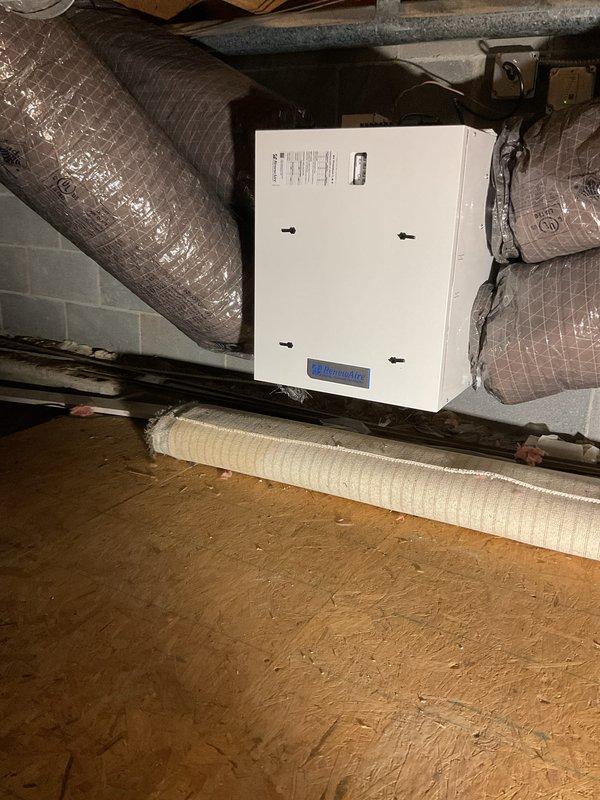 Installed Renewaire Energy Recovery Ventilator (ERV) unit in crawl space with complete ductwork integration. Mounted ERV equipment to structural supports, connected insulated flexible ductwork for fresh air intake and stale air exhaust, and established proper electrical connections. System commissioned and tested to ensure balanced ventilation and optimal indoor air quality performance.