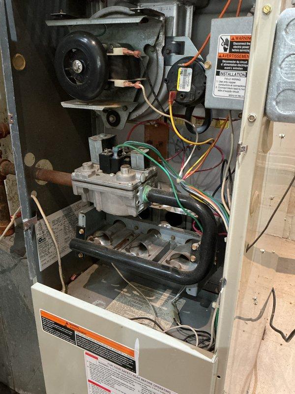 Completed annual furnace inspection and maintenance. Removed access panel and performed comprehensive visual inspection of all internal components including blower motor assembly, gas valve, burner assembly, heat exchanger, and electrical connections. Verified proper wire connections throughout unit with all colored wiring intact and secure at termination points. Inspected gas valve assembly for proper operation and connections. Examined burner tubes and heat exchanger for signs of deterioration, cracks, or carbon buildup - all components found in functional condition with normal operational wear. Verified blower motor operation and mounting integrity. Reviewed all safety labels and operational warnings posted on unit. Unit found to be operating within normal parameters with no immediate safety concerns or repair needs identified.