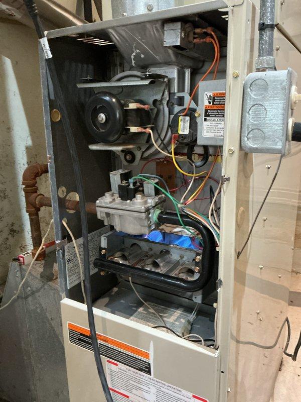 Completed annual furnace inspection and maintenance. Removed access panel and performed comprehensive visual inspection of all internal components including blower motor assembly, gas valve, burner assembly, heat exchanger, and electrical connections. Verified proper wire connections throughout unit with all colored wiring intact and secure at termination points. Inspected gas valve assembly for proper operation and connections. Examined burner tubes and heat exchanger for signs of deterioration, cracks, or carbon buildup - all components found in functional condition with normal operational wear. Verified blower motor operation and mounting integrity. Reviewed all safety labels and operational warnings posted on unit. Unit found to be operating within normal parameters with no immediate safety concerns or repair needs identified.
