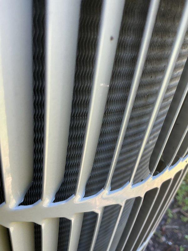 Completed recurring cooling system maintenance on outdoor condenser unit. Inspected heat exchanger coils and fins, which were found to be in good operational condition with minimal debris accumulation. Unit exterior frame and components showed normal weathering consistent with outdoor installation, with all structural elements intact and functioning properly.