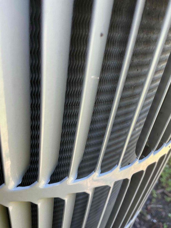 Completed recurring cooling system maintenance on outdoor condenser unit. Inspected heat exchanger coils and fins, which were found to be in good operational condition with minimal debris accumulation. Unit exterior frame and components showed normal weathering consistent with outdoor installation, with all structural elements intact and functioning properly.