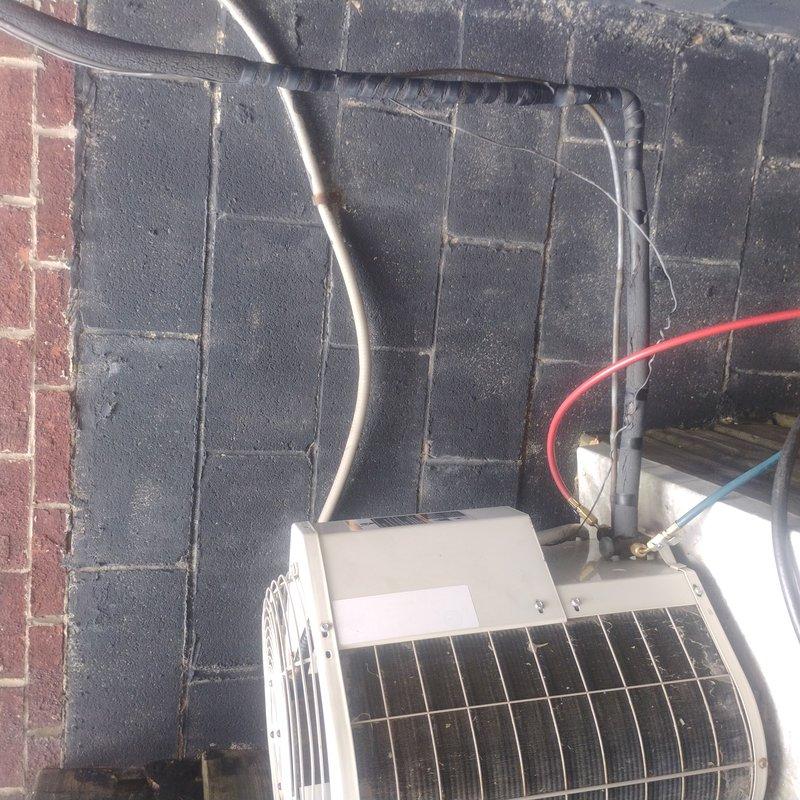 Conducted comprehensive HVAC estimate for complete system replacement at residential property with two existing white condenser units installed against exterior wall. Assessed current dual-unit configuration, including refrigerant line sets, electrical conduit routing, condensate drainage, and mounting provisions on concrete block and brick wall surfaces. Evaluated equipment placement considerations for deck-mounted unit and wall-adjacent installation, documented existing line set conditions with active service gauges attached, and provided detailed recommendations for full system upgrade including proper sizing, placement optimization, and code-compliant installation specifications.