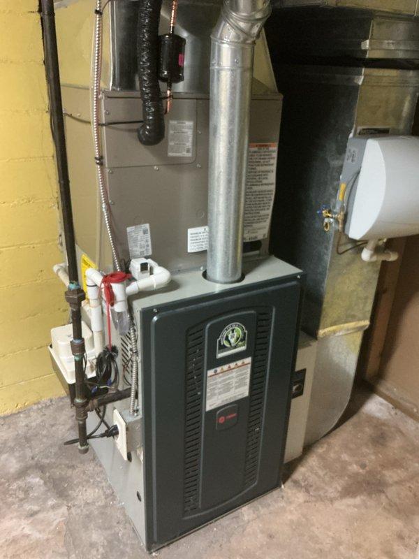Completed installation of new Bryant air conditioning system including outdoor condenser unit and indoor evaporator coil. Mounted condenser unit on protective pad against exterior foundation with proper clearances, connected refrigerant lines with insulated line set routed through basement wall, and integrated evaporator coil with existing furnace system. Installed all necessary electrical connections, completed refrigerant charging procedures, verified proper airflow and system operation, and conducted final performance testing to ensure optimal cooling efficiency and manufacturer specifications were met.