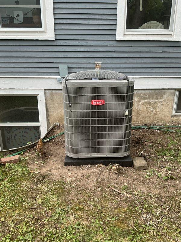 Completed installation of new Bryant air conditioning system including outdoor condenser unit and indoor evaporator coil. Mounted condenser unit on protective pad against exterior foundation with proper clearances, connected refrigerant lines with insulated line set routed through basement wall, and integrated evaporator coil with existing furnace system. Installed all necessary electrical connections, completed refrigerant charging procedures, verified proper airflow and system operation, and conducted final performance testing to ensure optimal cooling efficiency and manufacturer specifications were met.