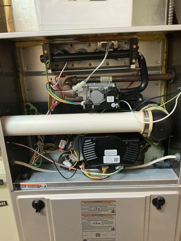 Completed comprehensive tune-up and preventive maintenance on multi-system HVAC unit including air conditioning and gas furnace components. Performed thorough inspection of furnace interior, gas valve assembly, heat exchanger, blower motor, electrical connections, and ductwork, verifying all components operating within manufacturer specifications. Documented equipment condition with photos showing internal components and air return grille requiring routine cleaning.