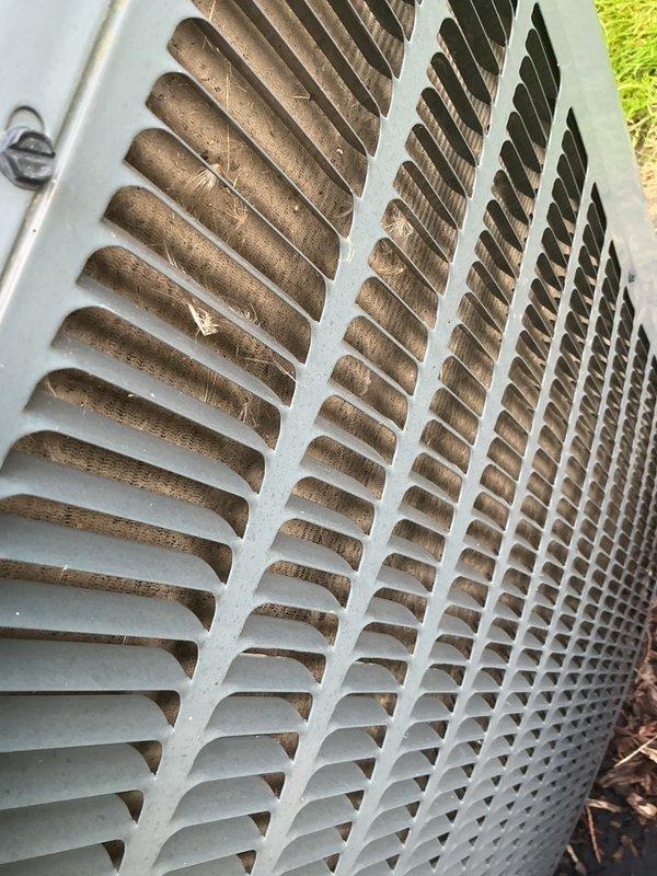 Completed scheduled air conditioning tune-up on Goodman outdoor condensing unit. Performed comprehensive system inspection, cleaned condenser coils which showed significant accumulation of dirt, dust, and organic debris on fins and louvers. Verified proper operation of condenser fan motor and compressor, checked refrigerant levels, and confirmed electrical connections were secure. Unit returned to normal operating condition with improved airflow efficiency following coil cleaning.