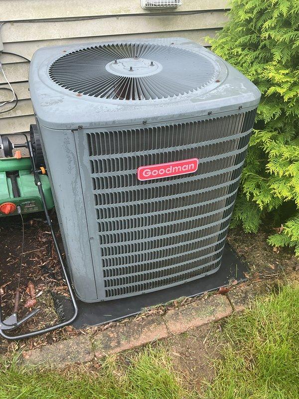 Completed scheduled air conditioning tune-up on Goodman outdoor condensing unit. Performed comprehensive system inspection, cleaned condenser coils which showed significant accumulation of dirt, dust, and organic debris on fins and louvers. Verified proper operation of condenser fan motor and compressor, checked refrigerant levels, and confirmed electrical connections were secure. Unit returned to normal operating condition with improved airflow efficiency following coil cleaning.