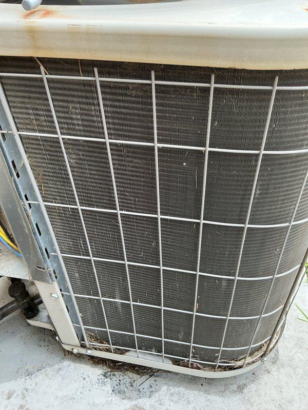 Completed routine maintenance on outdoor air conditioning condenser unit, including inspection of condenser coils, fan assembly, and protective housing. Unit showed normal wear from outdoor exposure with accumulated surface dirt on top housing and coils; verified proper operation of all components and confirmed unit is functioning within normal parameters.