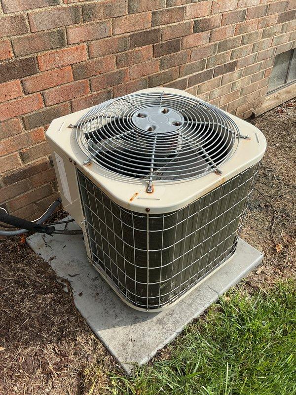 Completed routine maintenance on outdoor air conditioning condenser unit, including inspection of condenser coils, fan assembly, and protective housing. Unit showed normal wear from outdoor exposure with accumulated surface dirt on top housing and coils; verified proper operation of all components and confirmed unit is functioning within normal parameters.