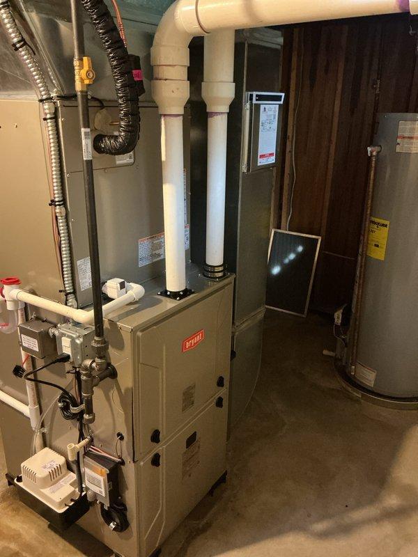 # HVAC Complete System Installation

Successfully completed a full HVAC system installation in a residential basement utility room. Installed a new high-efficiency furnace unit with properly configured white PVC venting system routed through the structure for intake and exhaust. Connected silver metallic supply ductwork with appropriate transitions and elbows to ensure proper airflow distribution throughout the home. Integrated a whole-home humidifier into the system with dedicated water supply lines and drainage connections to maintain optimal indoor humidity levels during heating season. Installed an air purification system to enhance indoor air quality and filtration. All ductwork connections were sealed and secured, including black flexible return air ducting. Electrical connections were completed to code with proper wire management and safety disconnects. Verified all PVC condensate drainage lines were properly pitched and secured. System startup and commissioning performed with a
