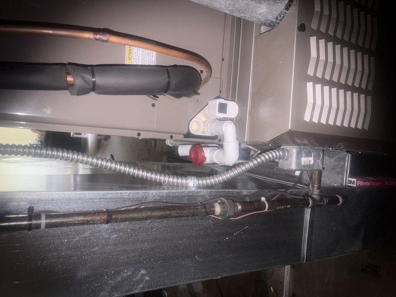 Completed comprehensive AC tune-up and maintenance inspection on air handler system. Upon arrival, investigated customer concern regarding condensation leaking into basement area. Inspected condensate drain line, PVC drainage components, and drain pan for proper operation and blockages. Examined copper refrigerant lines with insulation wrapping, verified connections and fittings for integrity. Checked all mechanical components within air handler cabinet including blower assembly, evaporator coil access, and ductwork connections. Documented system condition with interior photos showing drainage piping, flexible ductwork, refrigerant lines, and ventilation components. All systems operating within normal parameters following maintenance procedures.
