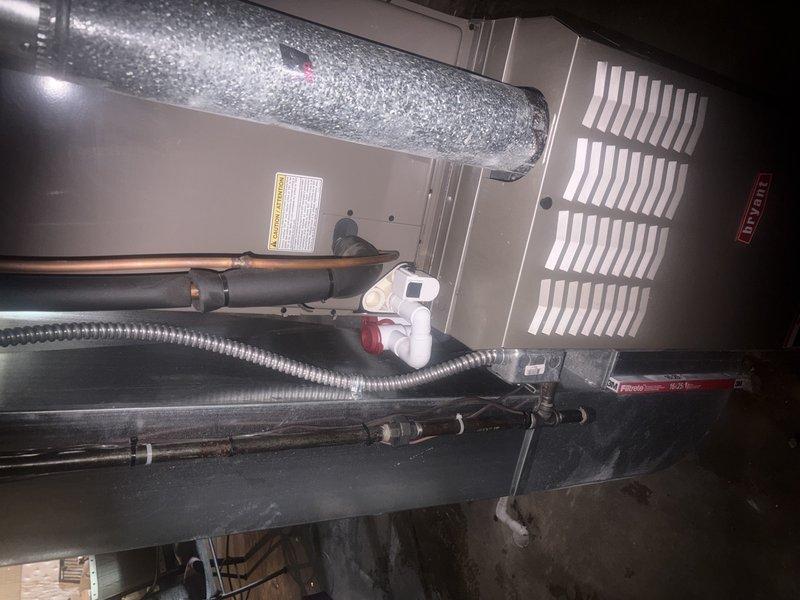 Completed comprehensive AC tune-up and maintenance inspection on air handler system. Upon arrival, investigated customer concern regarding condensation leaking into basement area. Inspected condensate drain line, PVC drainage components, and drain pan for proper operation and blockages. Examined copper refrigerant lines with insulation wrapping, verified connections and fittings for integrity. Checked all mechanical components within air handler cabinet including blower assembly, evaporator coil access, and ductwork connections. Documented system condition with interior photos showing drainage piping, flexible ductwork, refrigerant lines, and ventilation components. All systems operating within normal parameters following maintenance procedures.