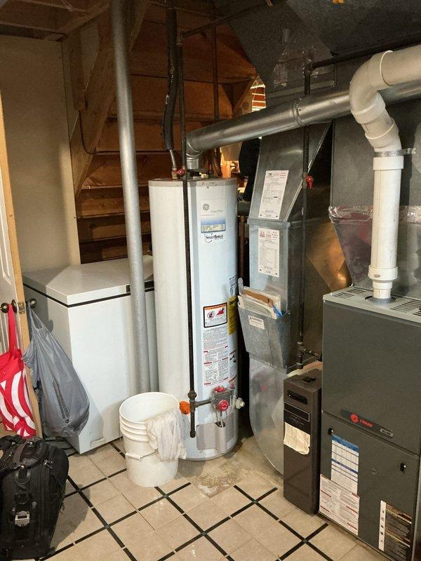Responded to service call for 20-year-old water heater with reported leak at discharge outlet and air conditioning system concerns. Upon inspection, documented existing GE SmartWater tanked water heater installation in basement mechanical room showing age-related wear and active leaking at discharge connection point. Photographed unit configuration including supply lines, pressure relief valve assembly, and surrounding plumbing connections for diagnostic documentation. Assessed overall system condition noting advanced age of equipment and evaluated discharge piping, flex connections, and shutoff valve accessibility. Provided customer with findings regarding leak source and recommended repair versus replacement options given unit age exceeding typical service life expectancy. Customer processed membership renewal for ongoing maintenance coverage with future maintenance appointment scheduled separately.