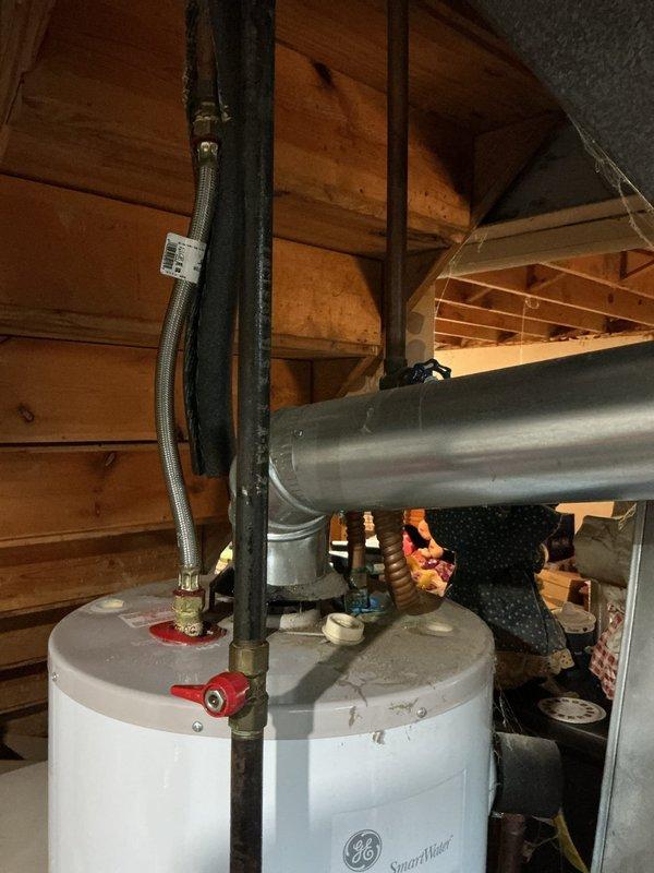Responded to service call for 20-year-old water heater with reported leak at discharge outlet and air conditioning system concerns. Upon inspection, documented existing GE SmartWater tanked water heater installation in basement mechanical room showing age-related wear and active leaking at discharge connection point. Photographed unit configuration including supply lines, pressure relief valve assembly, and surrounding plumbing connections for diagnostic documentation. Assessed overall system condition noting advanced age of equipment and evaluated discharge piping, flex connections, and shutoff valve accessibility. Provided customer with findings regarding leak source and recommended repair versus replacement options given unit age exceeding typical service life expectancy. Customer processed membership renewal for ongoing maintenance coverage with future maintenance appointment scheduled separately.