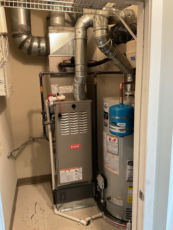 Completed full HVAC system replacement including installation of new Bryant furnace, air conditioning system, and residential water heater in utility closet. Furnace installation included proper venting with metallic ductwork configuration, gas line connections, and electrical wiring to control panel. Water heater installation featured mounting of blue expansion tank, copper and PEX plumbing connections, safety drainage pan with wheeled base and overflow tubing, and proper labeling of all safety specifications. All equipment secured according to manufacturer specifications with appropriate clearances maintained for service access and code compliance.