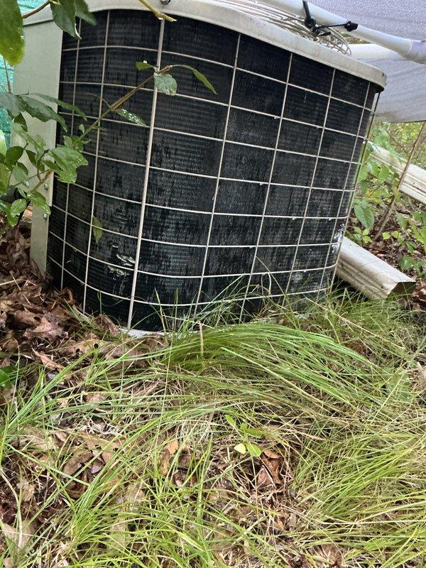 Completed scheduled air conditioning tune-up and preventive maintenance service. Upon arrival, found outdoor condenser unit significantly overgrown with vegetation, including vines and tall grass obstructing airflow through protective grille. Cleared all vegetation from around unit perimeter and removed plant growth from condenser cage to restore proper ventilation. Performed standard maintenance protocol including system inspection, cleaning of condenser coils, verification of refrigerant levels, electrical connection checks, and operational testing. Unit restored to proper working condition with unobstructed airflow.