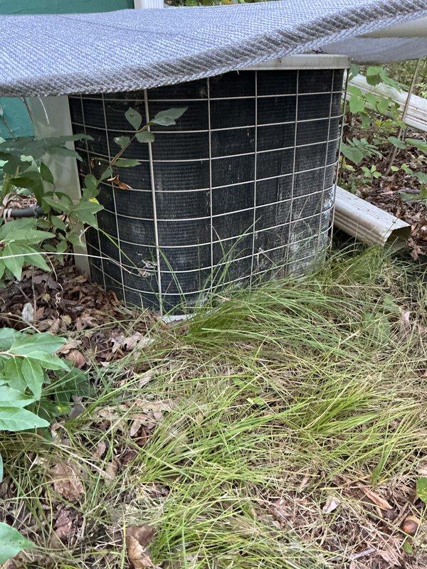 Completed scheduled air conditioning tune-up and preventive maintenance service. Upon arrival, found outdoor condenser unit significantly overgrown with vegetation, including vines and tall grass obstructing airflow through protective grille. Cleared all vegetation from around unit perimeter and removed plant growth from condenser cage to restore proper ventilation. Performed standard maintenance protocol including system inspection, cleaning of condenser coils, verification of refrigerant levels, electrical connection checks, and operational testing. Unit restored to proper working condition with unobstructed airflow.