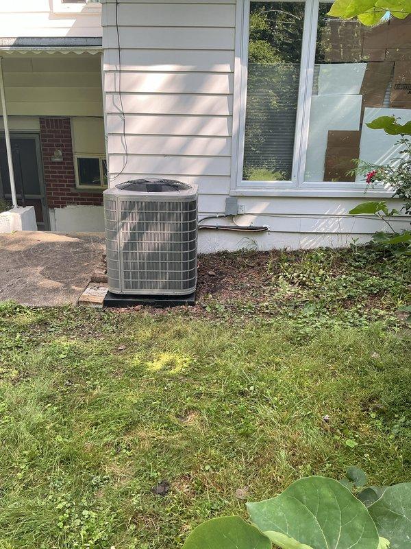 Completed full HVAC system installation including Bryant furnace, outdoor air conditioning condenser unit, and humidifier. Positioned exterior condenser on black pad against foundation with proper clearance, ran refrigerant lines and electrical connections vertically along siding to interior equipment. Interior installation features furnace with dual white PVC intake and exhaust venting routed through ceiling, integrated humidifier system, and proper copper line connections. All equipment professionally mounted with appropriate spacing, ductwork connections secured, and system tested for operational performance.