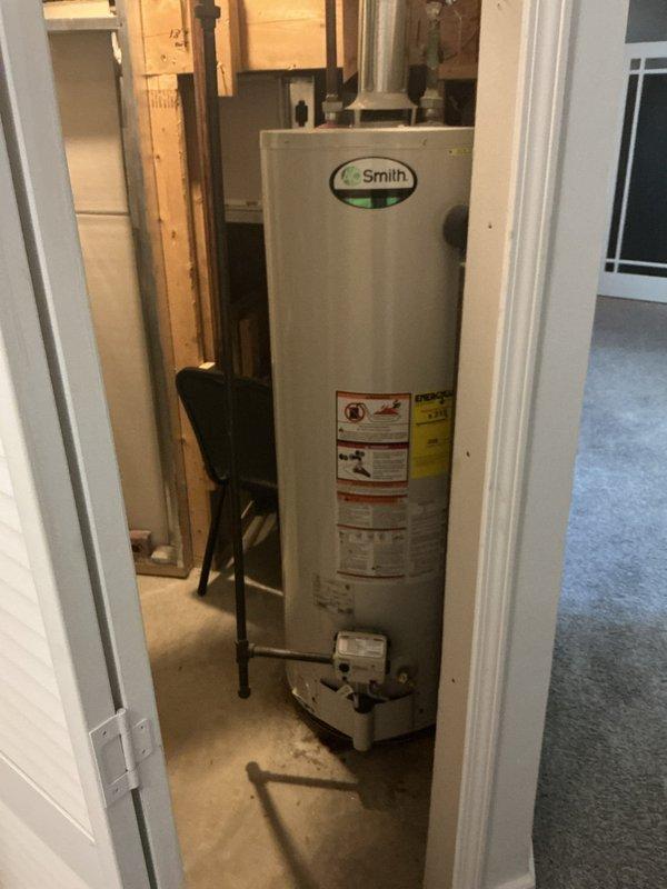 Responded to service call for reported boiler leak. Upon inspection, determined unit was actually an A.O. Smith residential water heater, not a boiler system. Conducted thorough visual assessment of the water heater installation, examining all piping connections, valves, and tank integrity. Inspected copper supply lines, inlet/outlet connections at top of tank, red-handled isolation valve, and secondary valve assembly. Checked base of unit and surrounding floor area for signs of active leaking or water damage. Documented equipment condition and plumbing configuration with photographs for service records and potential repair recommendations.