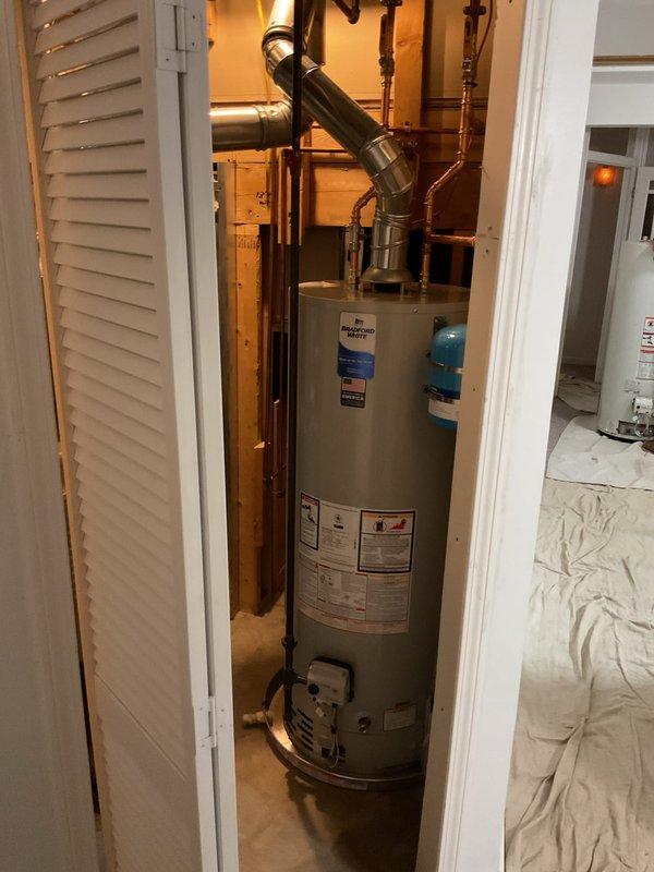 Installed a Bradford White 50-gallon natural gas tank water heater (Model RG250T6N) in residential utility closet. Connected copper supply lines, installed expansion tank, properly vented exhaust system, and verified all manufacturer specifications including gas pressure settings and clearance requirements were met per ANSI standards.