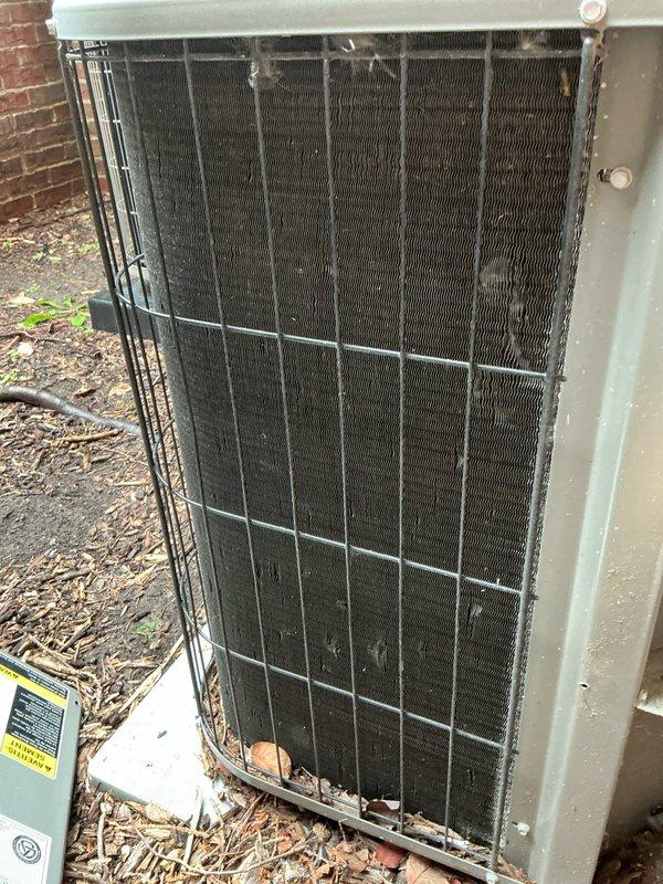 Completed comprehensive annual AC tune-up and maintenance on an 18-year-old outdoor condensing unit. Performed visual inspection, cleaned condenser coils which showed significant dirt and debris accumulation between fins, checked refrigerant levels, tested electrical connections, and verified proper system operation. Unit is functioning properly following maintenance service.