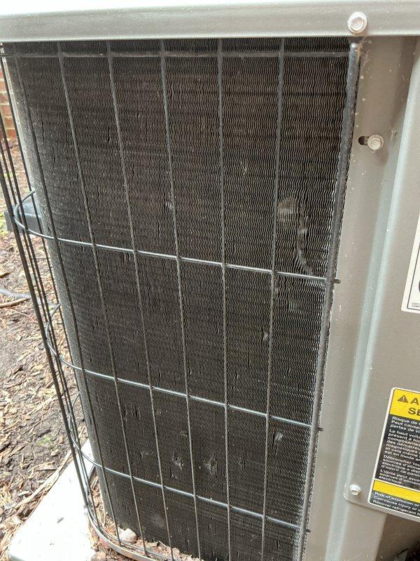 Completed comprehensive annual AC tune-up and maintenance on an 18-year-old outdoor condensing unit. Performed visual inspection, cleaned condenser coils which showed significant dirt and debris accumulation between fins, checked refrigerant levels, tested electrical connections, and verified proper system operation. Unit is functioning properly following maintenance service.