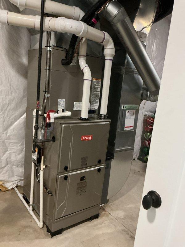Completed full HVAC system installation including new Bryant furnace and air conditioning unit. Installed and configured furnace with proper venting using white PVC intake and exhaust pipes with multiple elbows and joints, connected gas supply line with shutoff valve, and integrated black flexible metal ducting to existing ductwork system. Verified all connections, tested system operation, and ensured proper airflow throughout the residence.