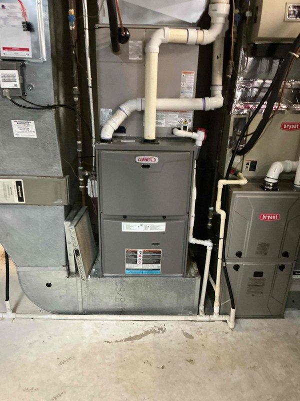 Completed installation of new HVAC system including Lennox furnace with integrated air conditioning coil and Bryant auxiliary equipment. System was fully installed with proper venting using white PVC piping, electrical connections secured through wall-mounted panels and junction boxes, and all refrigerant lines and gas connections properly routed and tested for safe operation.