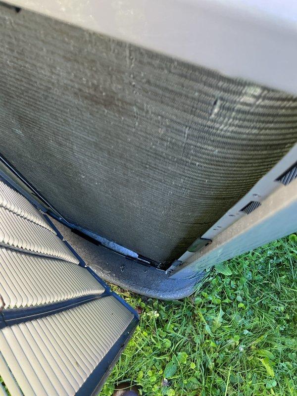 Completed scheduled air conditioning tune-up on dual outdoor HVAC system consisting of condenser unit and heat pump. Performed comprehensive maintenance inspection, cleaned condenser coils which showed accumulation of dirt and debris, checked refrigerant levels, tested electrical connections, and verified proper operation of both units. Noted concrete equipment pad showing significant cracking and deterioration with vegetation growth around units; recommended monitoring for future replacement to ensure proper equipment support and drainage.
