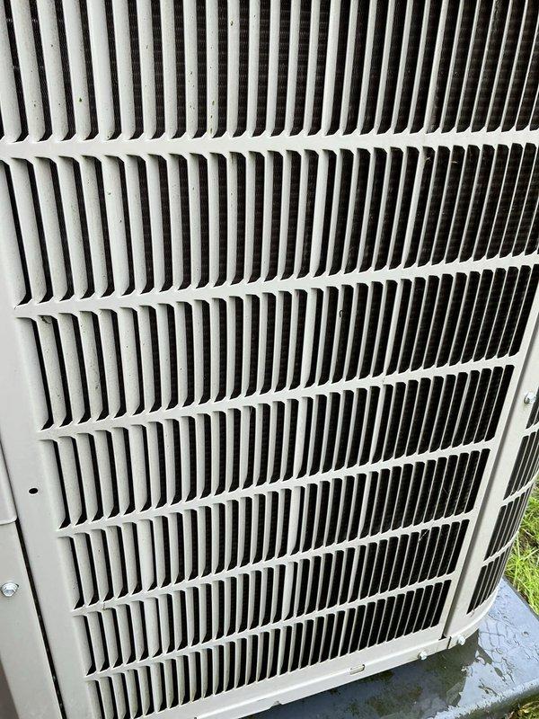 Completed scheduled air conditioning tune-up and preventative maintenance service on outdoor condensing unit. Performed comprehensive system inspection, documenting equipment condition with detailed photography of exterior cabinet and grille assembly showing normal weathering and dirt accumulation on louvers and fins. Verified unit operational status and completed all standard maintenance protocol items per manufacturer specifications.