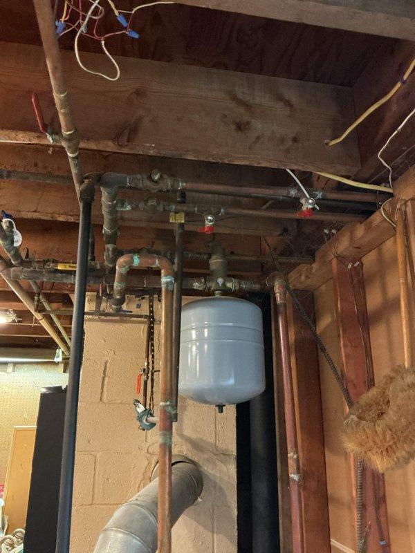 Responded to a no-heat service call on a 20-year-old hydronic boiler system with multiple heating zones experiencing progressive failure. Upon inspection, diagnosed malfunctioning automatic fill valve causing air entrainment throughout the distribution system, resulting in noisy operation in baseboard radiators and sequential zone failure. Serviced the autofill mechanism, purged air from supply and return lines, bled individual zone circuits, verified proper system pressure at expansion tank, and tested all zone valves for proper operation to restore full heating functionality across all zones.