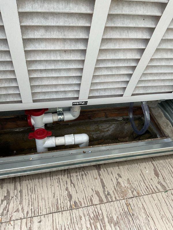 Installed NCP ComfortPack air handler unit in interior utility closet with proper ductwork connections and electrical hookup. Unit mounted vertically with insulated supply duct secured above and all safety labels properly displayed. Verified all plumbing connections, valves, and condensate drainage components are properly installed and accessible through exterior foundation access point.