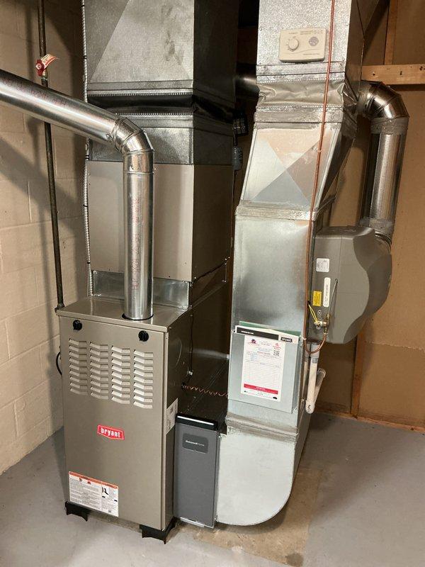 # HVAC Installation Completed

Successfully installed a new Bryant gas furnace system in residential basement location. The installation included proper positioning and mounting of the furnace unit on concrete flooring, connection of supply and return ductwork with appropriate transitions and elbows, and integration with existing HVAC infrastructure. All galvanized metal ductwork was routed through ceiling joists and properly secured to wooden framing members. The system was installed in accordance with manufacturer specifications and local building codes. All electrical connections, gas line hookups, and venting components were completed and tested for proper operation. The furnace was commissioned and verified to be functioning at optimal performance levels.