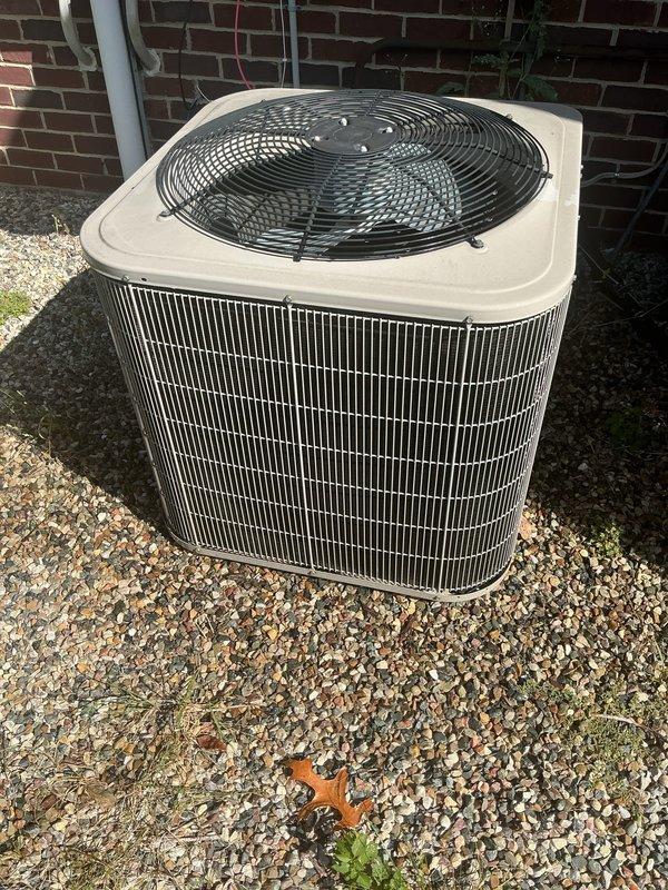 Performed routine HVAC maintenance on residential outdoor condensing unit. Inspected condenser coils, fan motor assembly, and electrical connections. Unit operating properly with adequate airflow through intake grilles and proper fan operation. Verified refrigerant levels, cleaned debris from surrounding area, and confirmed system cooling functionality. All components found in good working condition with no immediate service needs identified.