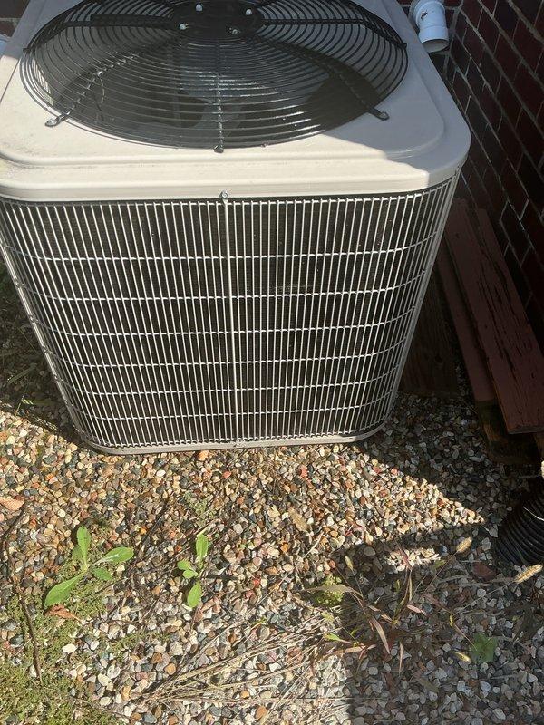 Performed routine HVAC maintenance on residential outdoor condensing unit. Inspected condenser coils, fan motor assembly, and electrical connections. Unit operating properly with adequate airflow through intake grilles and proper fan operation. Verified refrigerant levels, cleaned debris from surrounding area, and confirmed system cooling functionality. All components found in good working condition with no immediate service needs identified.