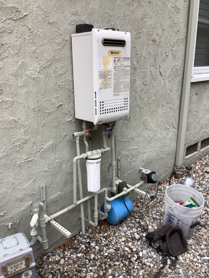 Plumber working on Tankless water heater service and Air conditioner Annual Maintenance 