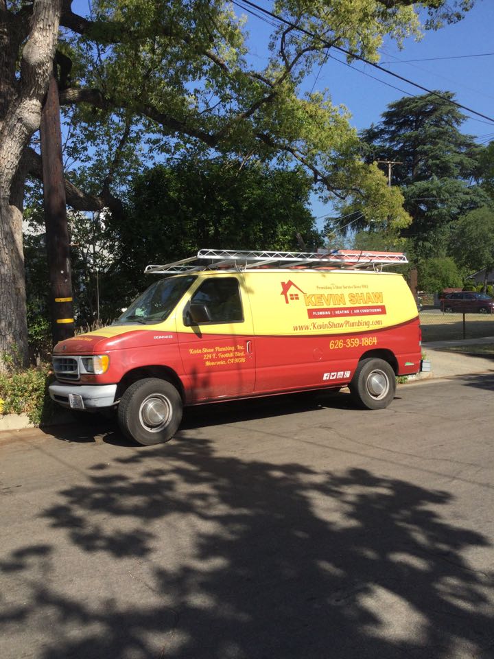 Plumber working on restoring proper pressure to shower unclogging clogged Lav sink and replacing drain pipes underneath sink 