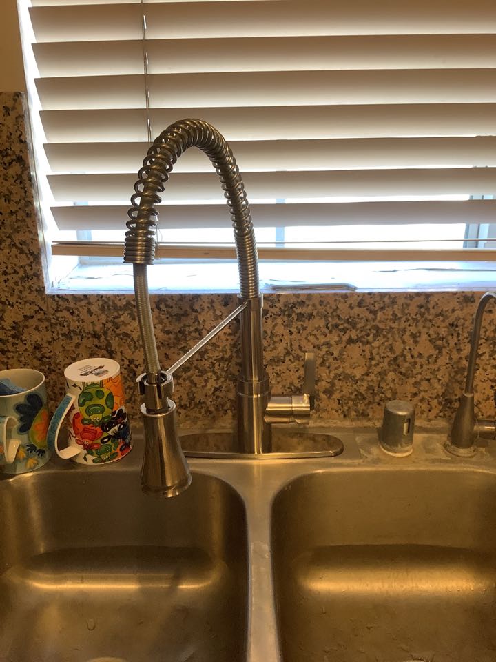 Best Plumber in Arcadia working on replacing kitchen faucet, with owner supplied kitchen faucet and owner supplied Insinkerator garbage disposal 