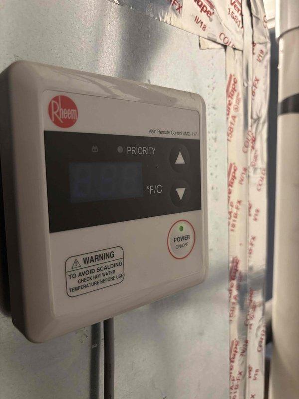 Diagnosed and serviced Rheem tankless water heater showing error code 11 which had resulted in no hot water. Performed diagnostic measurements in the utility area and verified proper functioning of the UMC-117 temperature control unit. Restored system operation after addressing the error code issue.