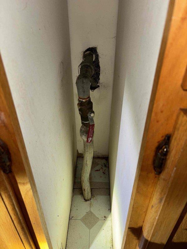 Responded to low water pressure complaint in residence with non-English speaking customers requiring translation assistance. Inspection revealed inadequate water supply valve configuration in utility alcove and exterior water line issues evidenced by disturbed pavers and soil. Cleared debris from line, adjusted valve settings, and restored water pressure to appropriate levels.
