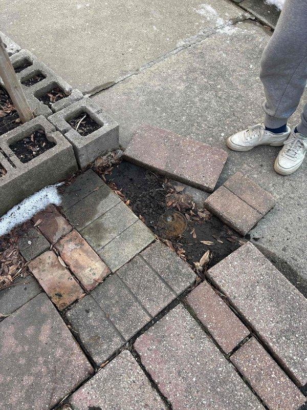 Responded to low water pressure complaint in residence with non-English speaking customers requiring translation assistance. Inspection revealed inadequate water supply valve configuration in utility alcove and exterior water line issues evidenced by disturbed pavers and soil. Cleared debris from line, adjusted valve settings, and restored water pressure to appropriate levels.