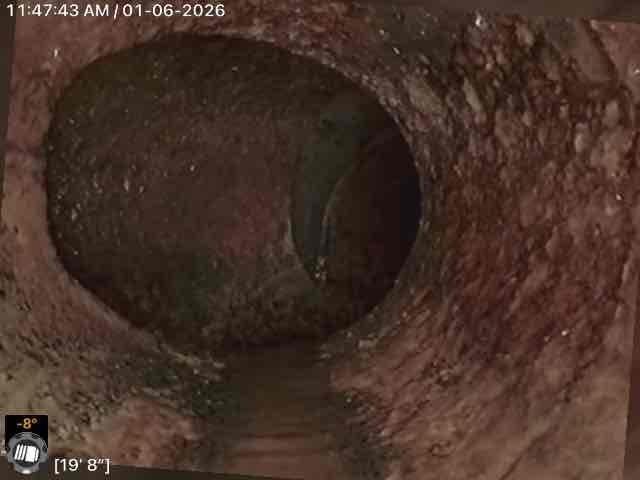Performed camera inspection of drain line, identifying significant corrosion and mineral buildup along pipe walls. Inspection reached approximately 19' 8" into the line, revealing partial water accumulation and potential deterioration requiring attention. Multiple inspection points were documented with timestamp photos for client reference.