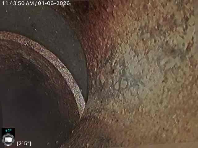 Performed camera inspection of drain line, identifying significant corrosion and mineral buildup along pipe walls. Inspection reached approximately 19' 8" into the line, revealing partial water accumulation and potential deterioration requiring attention. Multiple inspection points were documented with timestamp photos for client reference.